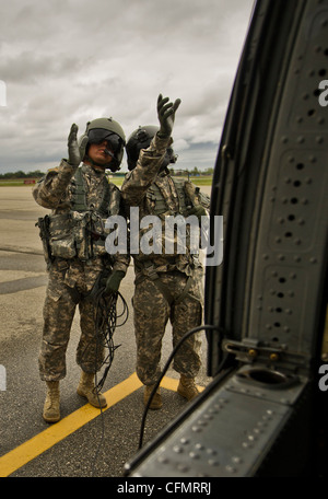 Sergent de l'armée américaine Greg Fernandez (à gauche) et Sgt. Oscar Sanchez, 40e Bataillon de l'aviation de la Compagnie Alpha, avant une mission d'entraînement sur l'aérodrome de l'Armée de Los Alamitos en soutien de Patriot Hook 2012, 16 mars 2012. Patriot Hook 2012 est un exercice parrainé par le Commandement de la Réserve de la Force aérienne qui déploie les éléments de contrôle des navires-citerne et des aéroglisseurs à trois endroits et assemble des unités de la Réserve de la Force aérienne, de la Marine, de la Garde côtière, de l'Agence fédérale de gestion des urgences, de la patrouille frontalière, des services de recherche en traumatologie et et d'autres organismes pour confirmer la viabilité des opérations coordonnées, de sécurité, de secours en cas de catastrophe et d'urgence. Banque D'Images