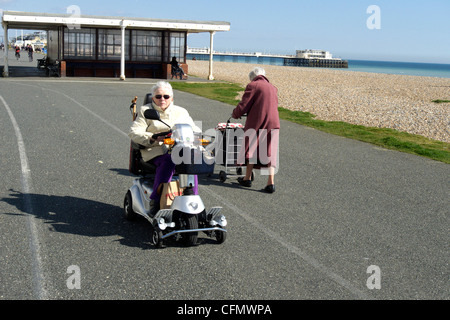 Worthing West Sussex Royaume-Uni une vieille dame sur une mobilité shoprider triporteur sur la promenade Banque D'Images
