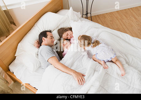 USA, Californie, Los Angeles, famille avec deux filles (8-9, 12-13) au lit Banque D'Images