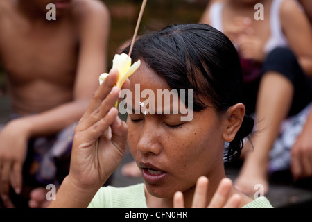 Fille priant lors d'une cérémonie religieuse à Bali, Indonésie, du Pacifique Sud, en Asie du sud-est, en Asie. Banque D'Images