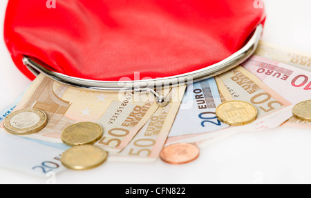 Sac à main rouge avec le papier-monnaie euro et le changement isolé sur fond blanc Banque D'Images