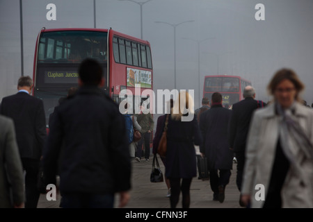 Les navetteurs et occupé le trafic traversant le pont de Londres sur un matin de smog Banque D'Images