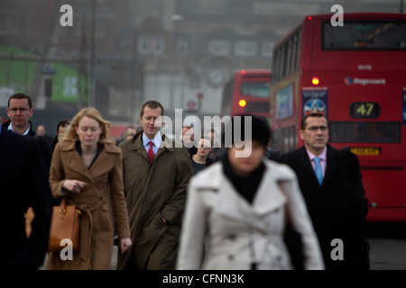 Les navetteurs et occupé le trafic traversant le pont de Londres sur un matin de smog Banque D'Images