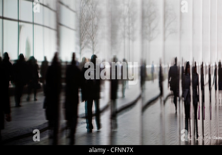 La réflexion de banlieusards de marcher dans les bâtiments de la zone de développement plus Londres dans le brouillard du matin Banque D'Images