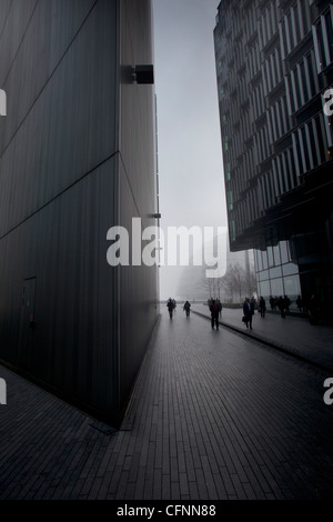 Les banlieusards de marcher dans les bâtiments de la zone de développement plus Londres dans le brouillard du matin Banque D'Images