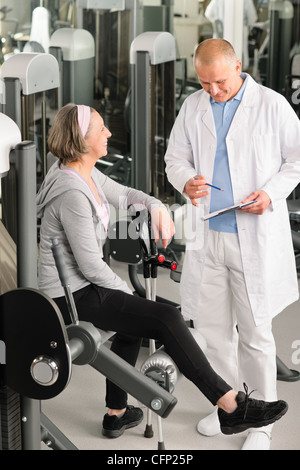 Thérapeute physique aider hommes senior woman exercise at gym Banque D'Images