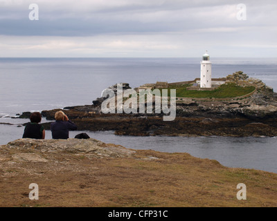 Deux randonneurs regardant Godrevy lighthouse, la baie de St Ives, Cornwall, UK Banque D'Images