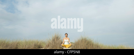 Mature Woman sitting on beach Banque D'Images