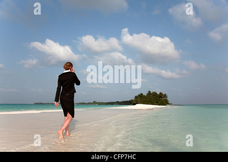 Woman with cell phone sur une plage tropicale, l'île de Kuramathi, Ari Atoll, Maldives, océan Indien, Asie Banque D'Images