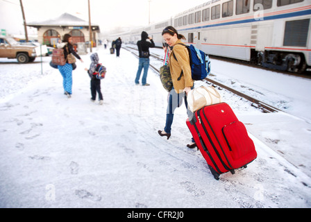 Woman pulling assurance dans la neige après le débarquement d'un train Amtrak en Oregon Banque D'Images