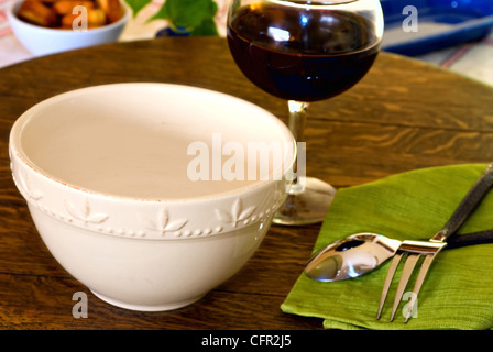 Bol blanc sur la table avec la mise place et le vin rouge Banque D'Images