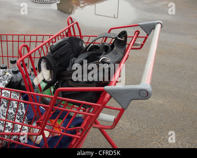 Panier d'épicerie en parking, avec sac à main, des gants et des magasins Banque D'Images