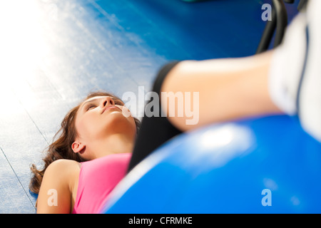 Fitness - Jeune femme faisant un entraînement sportif ou d'entraînement avec ballon de gymnastique dans une salle de sport Banque D'Images