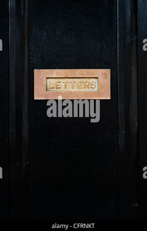 Lettre laiton fort sur une porte en bois noir. Cotswolds, Royaume-Uni Banque D'Images