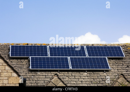 Des panneaux solaires sur une maison en pierre de Cotswold. Banque D'Images