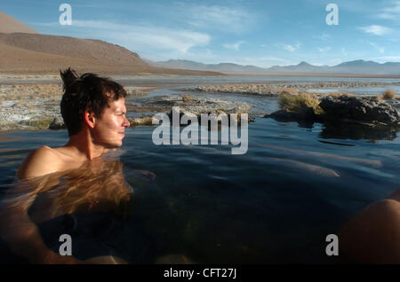 Dec 04, 2006 - Uyuni, Bolivie - assis dans une source chaude naturelle, un Allemand 'gringo' (étranger) donne sur un lac sur sa tournée de Salar de Uyuni, le plus grand et le plus grand lac salé au monde, et les autres sites naturels dans le sud de la Bolivie. Tous les jours des convois de véhicules 4x4 rempli de touristes passent par Banque D'Images