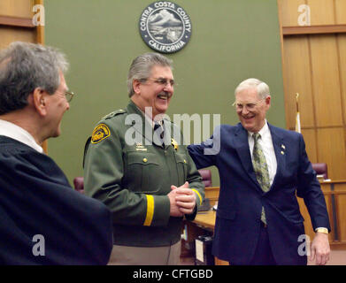 Contra Costa County Sheriff Warren Rupf (centre) est félicité par l'ancien procureur de district Gary T. Yancey (à droite) et la justice Mark B. Simons après qu'il est entamé son quatrième mandat au conseil des superviseurs Chambers dans Martinez, Californie le Vendredi, 12 janvier 2007. (Sat Nam tonne/Contr Banque D'Images