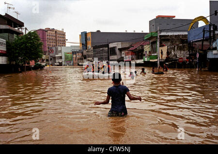 JAKARTA, INDONÉSIE, le 4 février 2007 : un bateau de sauvetage en mouvement comme les résidents de Jakarta à l'wade rue inondée à la principale zone d'affaires. La tempête a causé de graves inondations dans la capitale de l'Indonésie, comme river ont quitté leur lit, inondant des milliers d'habitations et d'affaires. Photo par Edy Purnomo/JiwaFoto Banque D'Images