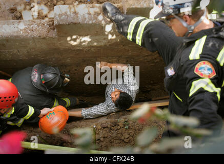 HLtrenchCollaspe270129x001.jpg 4/4/2007 CITY HEIGHTS (San Diego, Californie) États-Unis d'  les pompiers et secouristes de la San Diego Fire-Rescue Ministère travailler pour libérer un homme coincé dans la terre après la tranchée, lui et deux autres hommes ont été creusé à côté d'un mur de soutènement à un complexe de condo au 4230 5R2 Banque D'Images