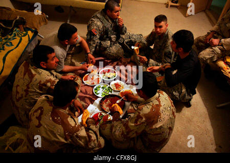 Mar 28, 2007 - Shakarah, Diyala, l'IRAQ - Le s.. BEN MENDOZA, de Killeen, centre, et le Sgt. NEIL FRERICK, d'Elgin, dîner style irakien à la base de patrouille K-Wal dans Shakarah, l'Iraq, le mercredi 28 mars 2007. Les Irakiens et les Américains vivent ensemble et ont des liens communs où ils peuvent. Première Cavalr Banque D'Images