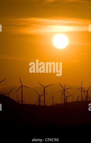 Les hélices tournent sur la production d'énergie éolienne éoliennes connu sous le nom de moulins à vent qui produisent de l'énergie au lever du soleil. Banque D'Images