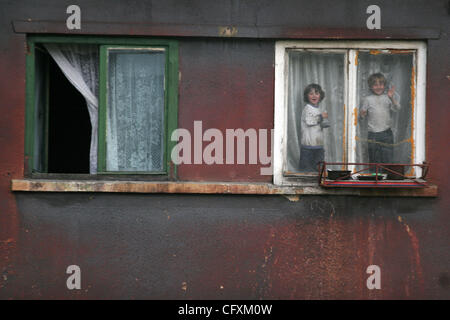 18 avril 2007 - Copsa Mica, Transylvanie, Roumanie - Enfants à la fenêtre. Copsa Mica, petite ville de Transylvanie était considéré comme l'un des cinq pires sites industriels pollués du monde communiste. Une fonderie de zinc et une usine de noir de carbone et les métaux lourds crachant de la poussière noire sur une longueur de 25 ou Banque D'Images