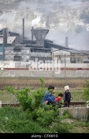 18 avril 2007 - Copsa Mica, Transylvanie, Roumanie - Le père avec ses enfants avec l'usine Sometra plomb à l'arrière-plan. Copsa Mica, petite ville de Transylvanie était considéré comme l'un des cinq pires sites industriels pollués du monde communiste. Une fonderie de zinc et une usine de noir de carbone rejetés Banque D'Images