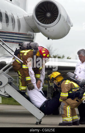 Jun 07, 2007 - Boca Raton, FL, USA - Boca Raton Fire-Rescue Capt Jeff MATHESON, gauche, et Arnaldo RODRIGUEZ, pompier, faire droit Universal Jet Le capitaine et le président MICHAEL MCCAULEY en bas de l'escalier d'un Gulfstream 3 après qu'il fait semblant d'être vaincu par les vapeurs d'un additif de carburant lors d'un mu Banque D'Images