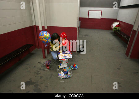 Bloomington, MN - 2/11/2007 la mère de Matthieu.Ang consoles Joan sa fille Alena qui s'est fâché qu'elle ne pouvait pas souffler les bougies sur son gâteau pour Matthews 10e anniversaire. La partie de fortune a été assemblé dans un vestiaire du Bloomington Ice jardin après un jeu de tournoi. Joan allumé trois c Banque D'Images