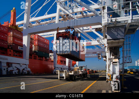 À l'aide d'une grue de chargement de conteneurs spécialisés, est déchargé d'un cargo dans un chariot à une installation de fret conteneur à Jersey City, New Jersey. Banque D'Images