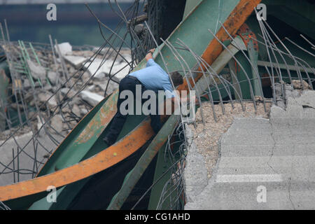 Un agent de police de Minneapolis ont fouillé les décombres de la I-35W bridge mercredi après-midi. Informations générales : JEFF WHEELER • jwheeler@startribune.com MINNEAPOLIS - 8/1/07 - l'I-35W pont enjambant la rivière Mississippi, à proximité du centre-ville de Minneapolis s'est effondré alors qu'ils sont bouchés par l'heure de pointe W Banque D'Images