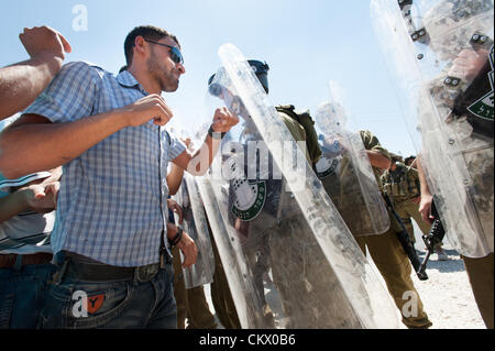 AL MA'SARA, CISJORDANIE - 24 août 2012 : les Palestiniens face à des soldats israéliens lourdement armés dans une manifestation non-violente hebdomadaire contre le mur de séparation qui aurait coupé le village d'al Ma'sara de ses terres agricoles. Banque D'Images