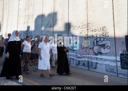 Bethléem, CISJORDANIE - 24 août 2010 : les religieuses catholiques à la tête d'une procession de prière transmettre un message graffiti lire 'Pas de Paix sans Justice" sur le mur de séparation israélien dans la ville cisjordanienne de Bethléem. Banque D'Images