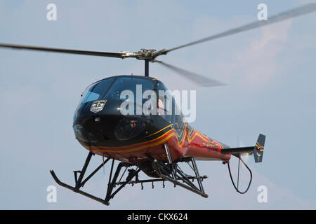 Lesnovo, Bulgarie, 24e Août 2012. Hélicoptère Enstrom 480 lumière planant au-dessus du champ de l'air. Cet avion est équipé comme une récolte duster (notez le rack des buses de pulvérisation sous le fuselage). Credit : Johann Brandstatter / Alamy Live News Banque D'Images