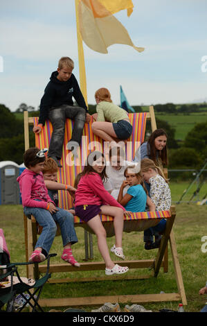 Dimanche 26 août 2012 : un groupe d'enfants jouant ensemble à l'extérieur sur une chaise longue sur grand grand format géant le Grand Festival Hommage, Aberystwyth au Pays de Galles au Royaume-Uni. Le seul week-end Pays de Galles uniquement dédié à l'événement musique hommage bandes. August Bank Holiday Weekend. photo©keith morris ©keith morris 2012 Banque D'Images