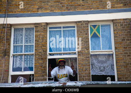 26 août 2012, Dimanche, Nottinghill Carnival , Nottinghill Gate, London, UK - 10.11 H . Dans l'homme tshirt jamaïcaine saluant les passants à partir de la fenêtre. Credit : Miguel Sobreira / Alamy Live News Banque D'Images