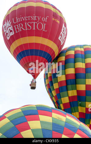 26 août 2012. Le John Harris (G-CDWD) Université de Bristol balloon décolle à côté du Colin Hodges G-CFFL Lindstrand LBL-317un ballon à l'Aerosaurus Tiverton montgolfières de Tiverton, Devon, UK. Banque D'Images