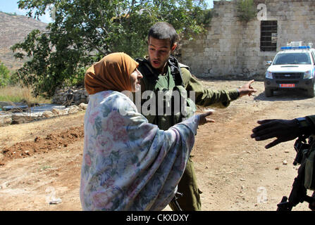 28 août 2012 - Naplouse, Cisjordanie - Des soldats israéliens d'arrêter une femme palestinienne d'atteindre sa maison après des colons juifs de la colonie israélienne de Livona ont attaqué le domicile familial à l'Al-Loban village, blessant quatre des résidents et de détruire leur voiture. (Crédit Image : © Nedal Eshtayah ZUMAPRESS.com)/Images/APA Banque D'Images
