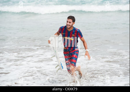 LAS PALMAS, îles Canaries, Espagne-29 août 2012 : jeunes surfeurs non identifiés de l'Université École de Surf et Surf Camp Las Palmas au cours d'une réunion informelle de la concurrence, formé comme un match de foot avec 11 surfeurs dans chaque équipe, une équipe est vêtus de T-shirts de football club F.C. Barcelone, l'autre par le Real Madrid. Banque D'Images