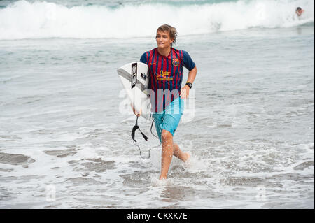 LAS PALMAS, îles Canaries, Espagne-29 août 2012 : jeunes surfeurs non identifiés de l'Université École de Surf et Surf Camp Las Palmas au cours d'une réunion informelle de la concurrence, formé comme un match de foot avec 11 surfeurs dans chaque équipe, une équipe est vêtus de T-shirts de football club F.C. Barcelone, l'autre par le Real Madrid. Banque D'Images