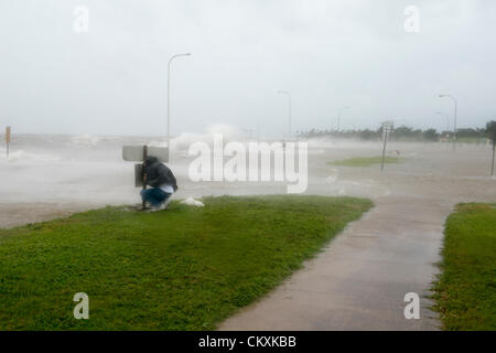 New Orleans, USA. 28 août, 2012. Un résident de la Nouvelle-orléans hunkers en bas derrière un panneau pour protéger son appareil photo de la touche de salé l'ouragan Isaac's de tempête le mardi 28 août 2012 à partir du lac Pontchartrain southshore sur Lakeshore Drive et Canal Boulevard. De nombreux résidents ont payé une visite de dernière minute du lac pour assister au raz-de-marée et les inondations de Lakeshore Drive. Banque D'Images