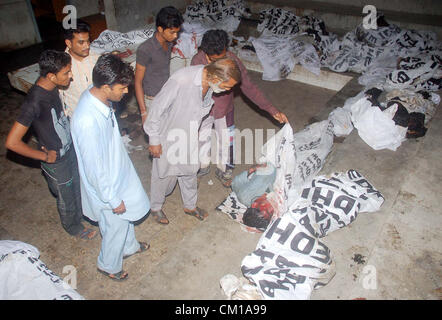 Karachi, Pakistan. SEP 12, 2012. Les gens se rassemblent près de cadavres de victimes, qui ont été tués dans un incendie survenu en usine de confection à Baldia Town, à l'hôpital Jinnah de Karachi le mercredi, Septembre 12, 2012. Le nombre de morts dans l'usine de vêtements en feu dévastateur Baldia Town a atteint 289, ce qui soulève des préoccupations au sujet de la sécurité au travail, ont dit. Banque D'Images