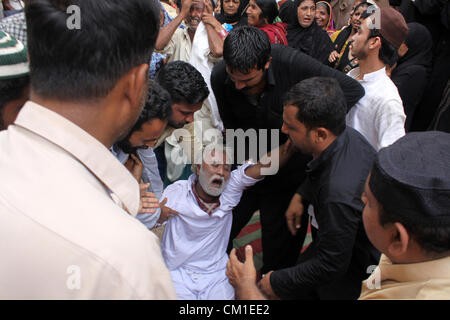 Membres de la famille de deux jeunes frères pleurent lors de funérailles à Karachi le 13 septembre 2012. Au moins 289 ouvriers étaient brûlés lorsque wild incendie a ravagé une usine de confection de mercredi. Banque D'Images