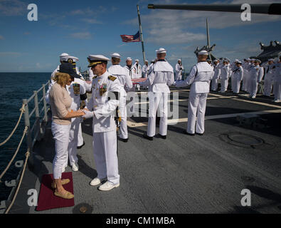 Le capitaine de l'US Navy Steve Shinego, commandant de l'USS Mer philippine Carol confort Armstrong, l'épouse de Neil Armstrong, après avoir commis l'Armstrong reste à la mer au cours de l'inhumation en mer service pour son mari l'astronaute Neil Armstrong Apollo 11 le 14 septembre 2012 à bord du USS mer des Philippines dans l'océan Atlantique. Armstrong, le premier homme à marcher sur la lune au cours de la mission Apollo 11 de 1969, est mort le 25 août. Il a été 82. Banque D'Images