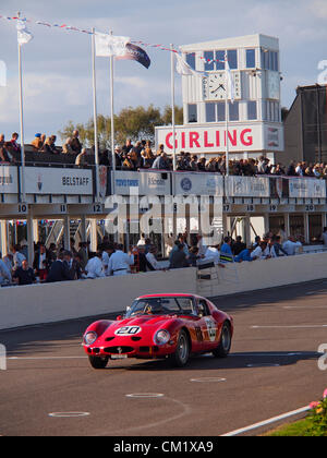 Goodwood Revival Jour de pratique vendredi 14 septembre.2012. Numéro 20 Ferrari portant une livrée rouge vif s'approche de la ligne d'arrivée en face d'ingénieurs et de spectateurs dans les fosses. Banque D'Images