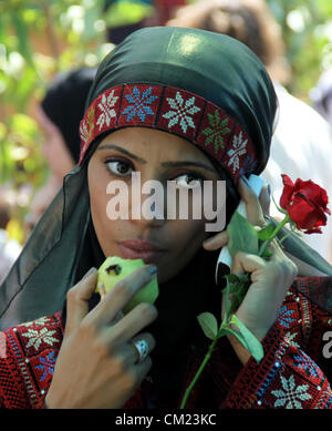 17 septembre 2012 - Qalqilya en Cisjordanie, territoire palestinien - une fille palestinienne porte une robe traditionnelle et mange un fruit de goyave, au cours de la goyave festival dans la ville de Cisjordanie Qalqilya, 17 septembre 2012 (Crédit Image : © Nedal Eshtayah ZUMAPRESS.com)/Images/APA Banque D'Images