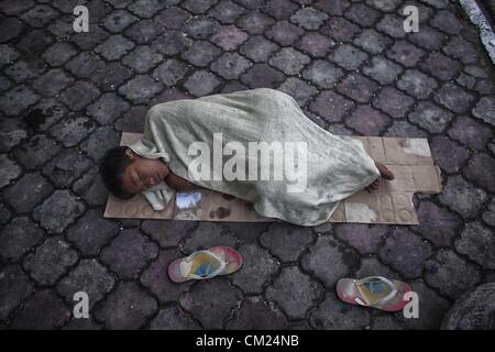 17 septembre 2012 - Phnom Penh, Cambodge - un jeune Cambodian dort sur un morceau de carton mince le long d'une rue de Phnom Penh lundi. (Crédit Image : © David Longstreath/ZUMAPRESS.com) Banque D'Images