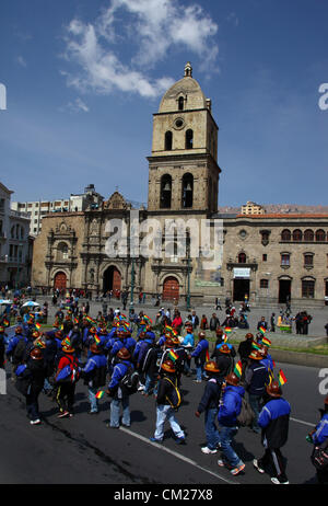 LA PAZ, BOLIVIE, le 18 septembre 2012. Mineurs coopérative passer l'église de San Francisco pendant une marche pour exiger le gouvernement est conforme aux promesses de leur donner une plus grande part de la concession de la mine près de Colquiri Oruro. Coopérative et les salariés mineurs qui travaillent pour la société minière d'état COMIBOL ont été contester le contrôle de la mine pendant plusieurs semaines, avec l'escalade des protestations dans la semaine dernière. Les mineurs salariés exigent la mine est nationalisée et l'arrêté de travailler il y a des coopératives. Banque D'Images