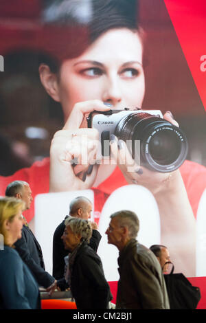 Les visiteurs passent devant la grande affiche publicité appareil photo Canon sur deuxième journée bi-annuelle de la photographie et imagerie Photokina salon de Cologne en Allemagne ; le mercredi 19 septembre 2012. Banque D'Images