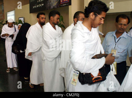 Pèlerins pakistanais se tenir dans une file d'attente à l'Aéroport International Jinnah Hajj Terminal au conseil du premier vol à partir pour Paris, alors qu'ils partent pour le pèlerinage annuel en Arabie Saoudite, à Karachi le Jeudi, Septembre 20, 2012. Autour de 1, 25000 pèlerins du Pakistan devraient partir pour le hajj annuel congrégation à La Mecque. Banque D'Images